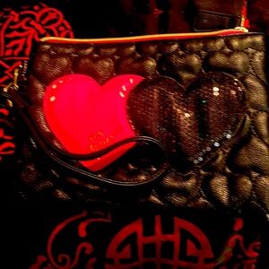 Slight used Betsey Johnson wristlet with a black sequin and pink heart
